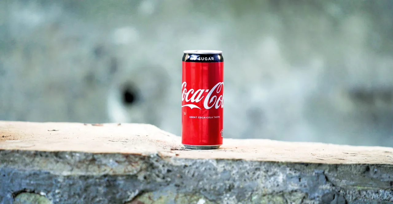 Can of coca cola sitting on a stone wall