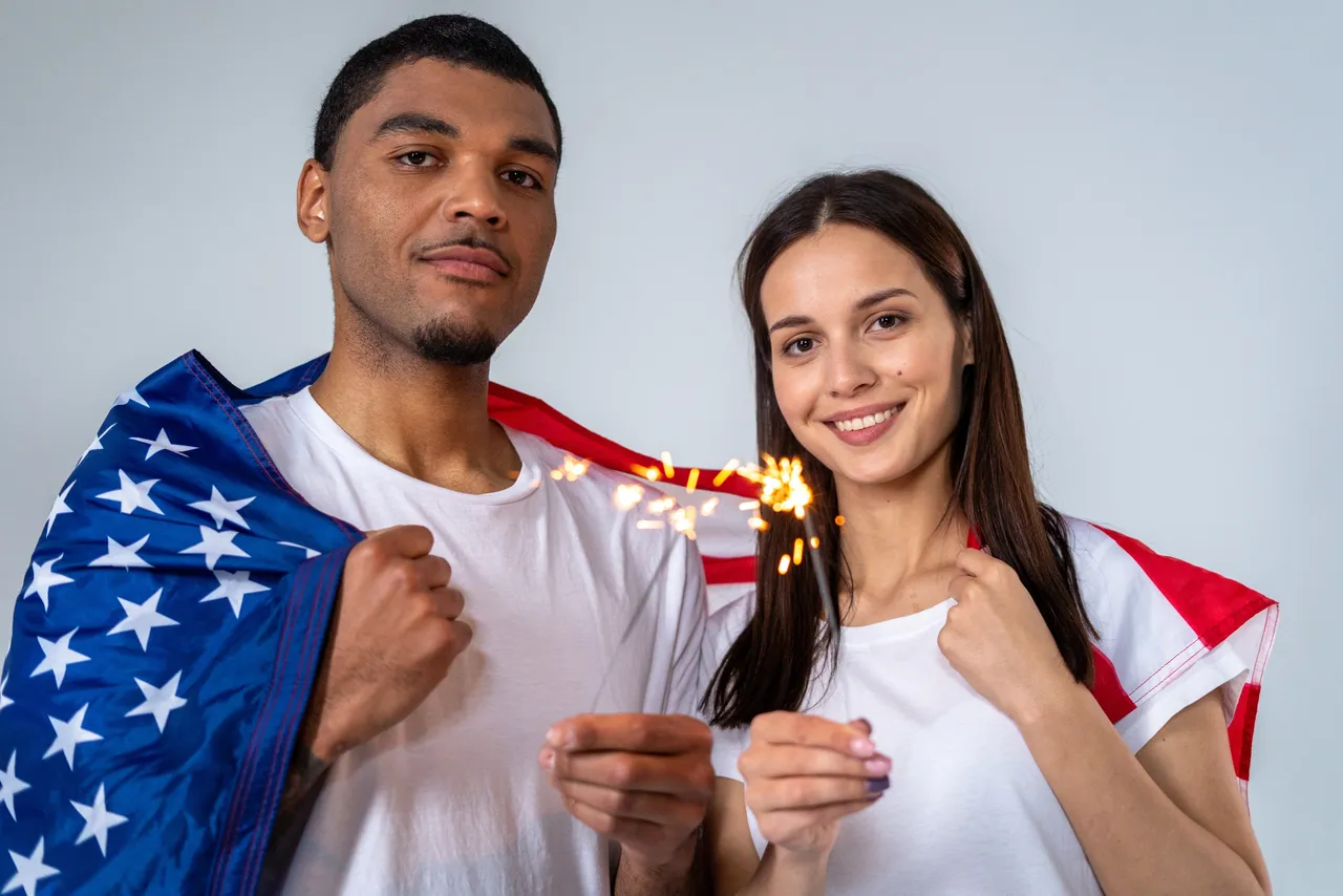 Man and woman with american flag wrapped around their shoulders